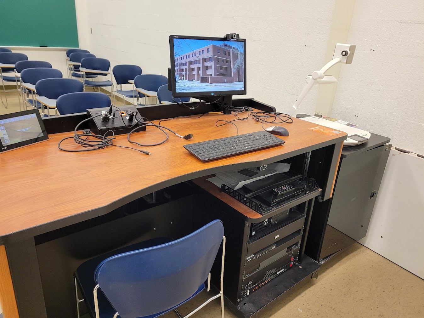 A view of the open cabinet with a computer monitor, VGA and HDMI inputs, a touch panel controller, document camera, and audio visual rack.