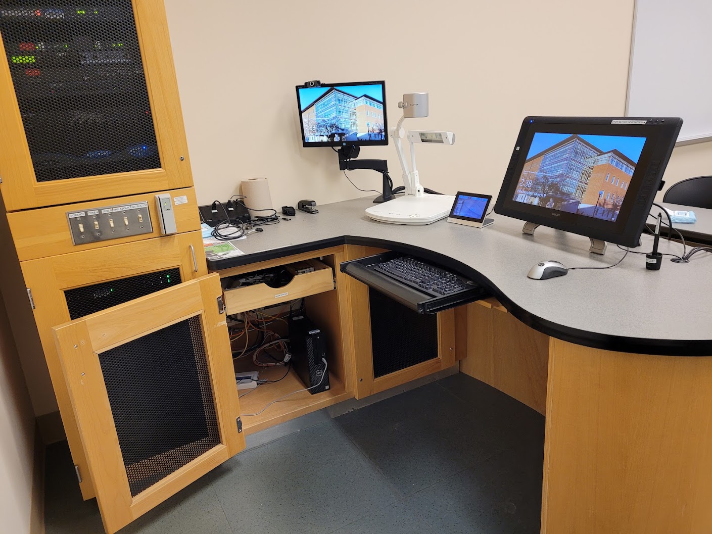 A view of the open cabinet with a PC, Wireles, HDMI and VGA inputs, a touch panel controller, and document camera. 