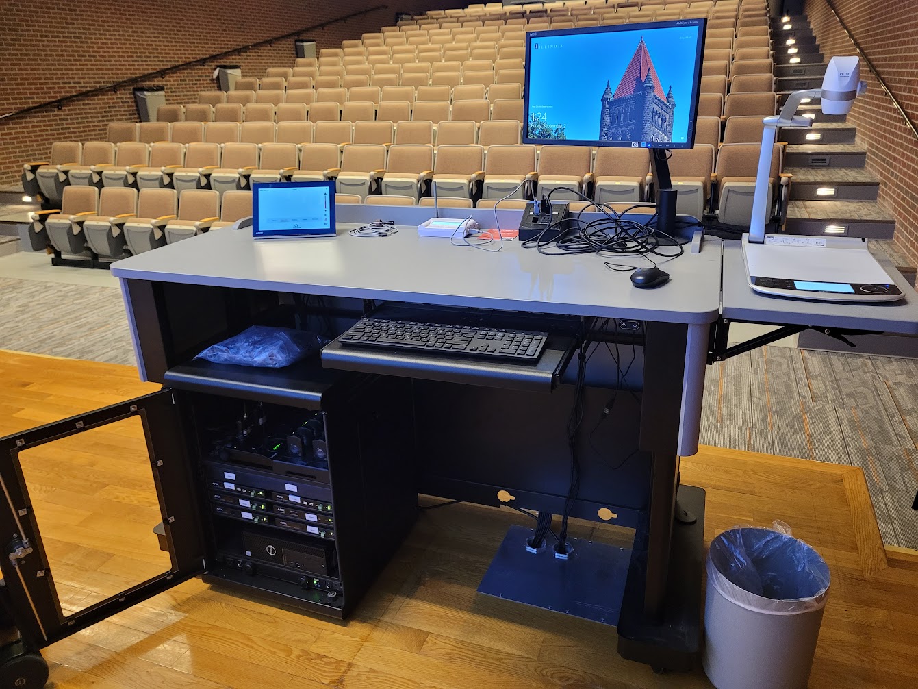 A view of the open cabinet with a computer monitor, VGA input, a touch panel controller, document camera, and audio visual rack. 