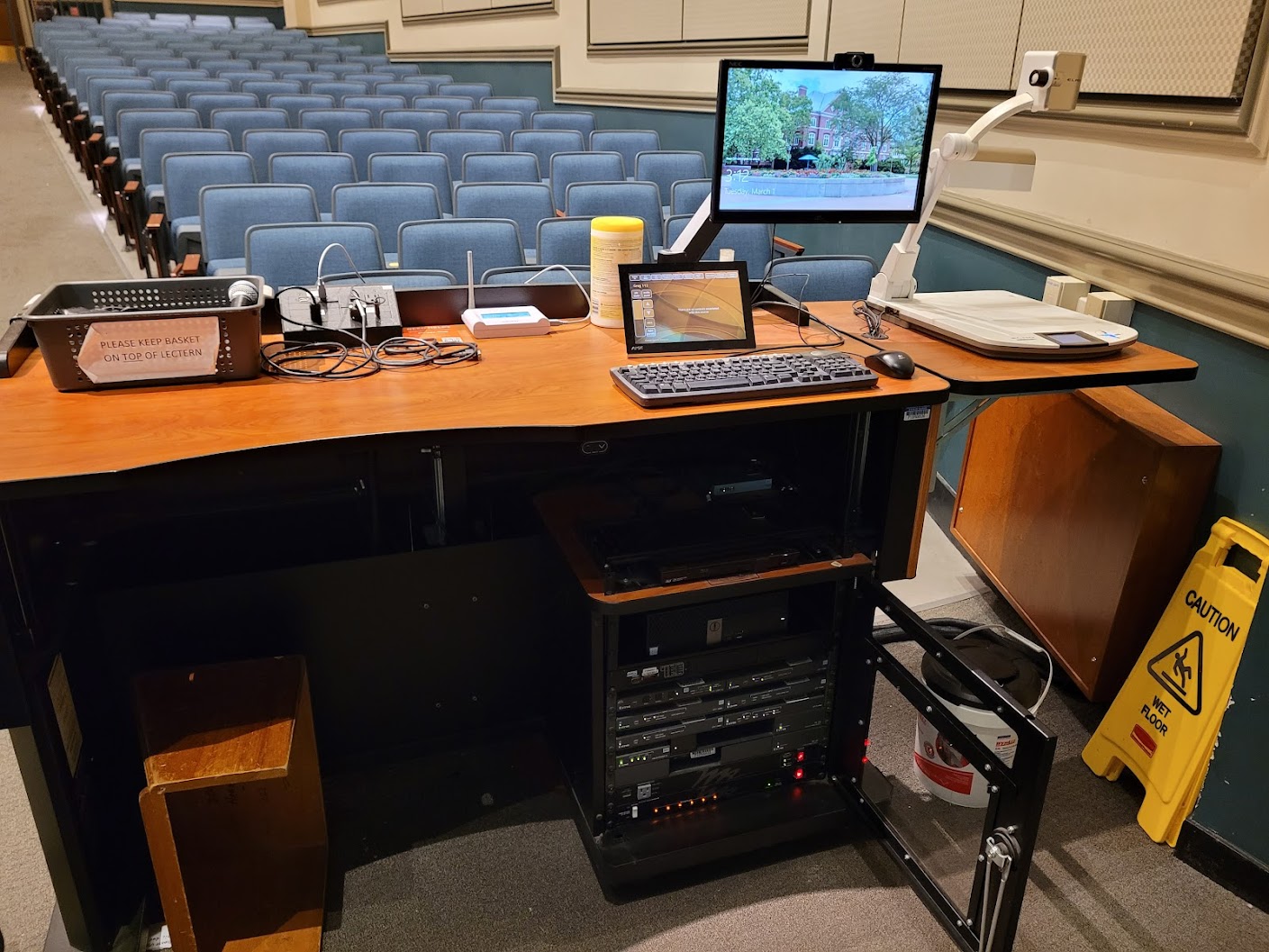 A view of the open cabinet with a computer monitor, HDMI inputs, a touch panel controller, document camera and audio visual rack.