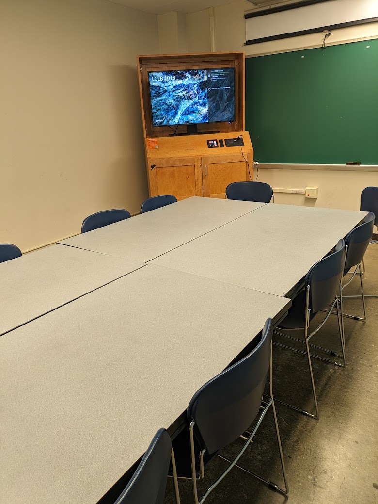 A view of the classroom with movable tables and chairs, and chalkboard