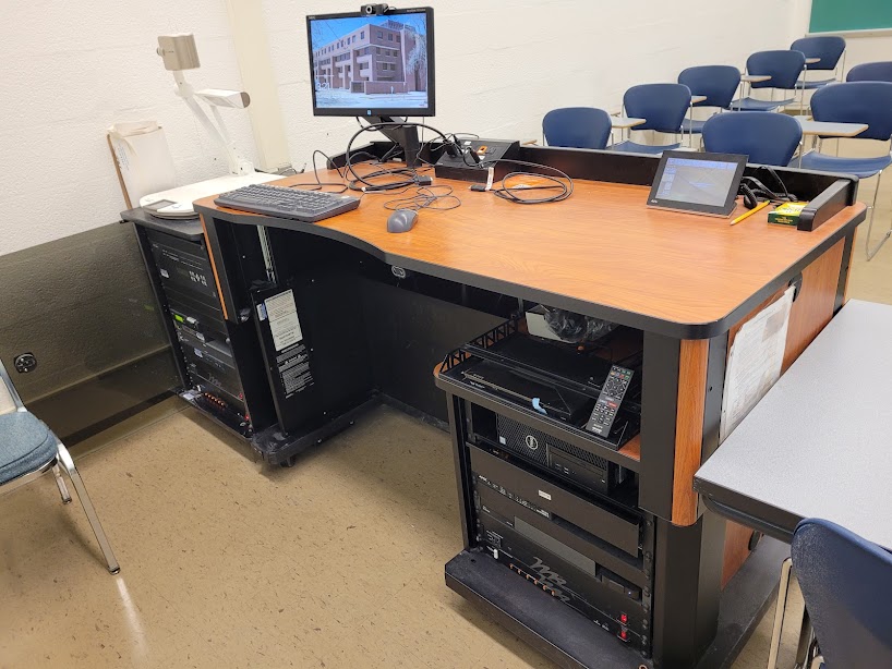 A view of the open cabinet with a computer monitor, VGA and HDMI inputs, a touch panel controller, document camera, and audiovisual rack.