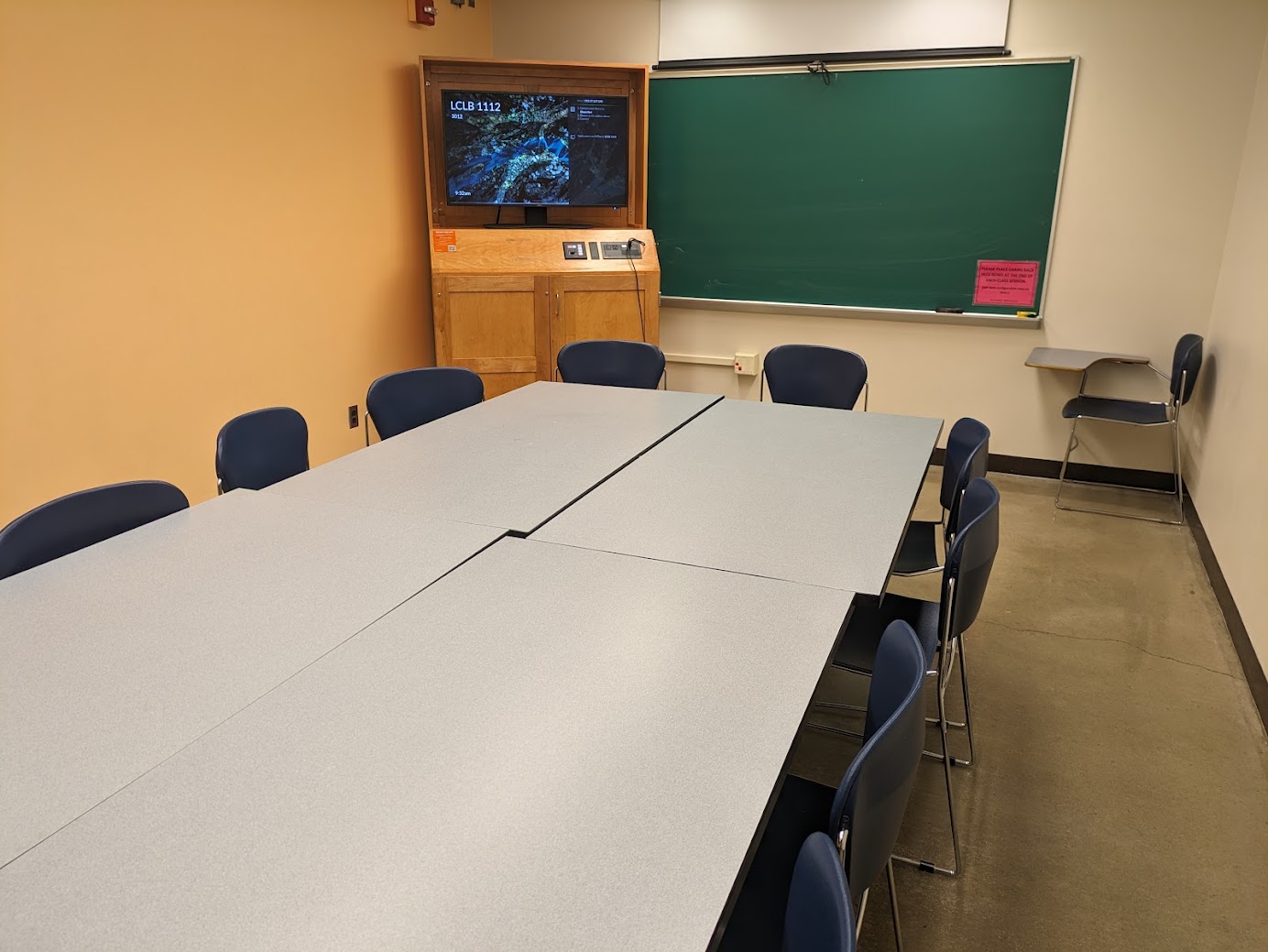 A view of the classroom with moveable tables and chairs, and chalkboard