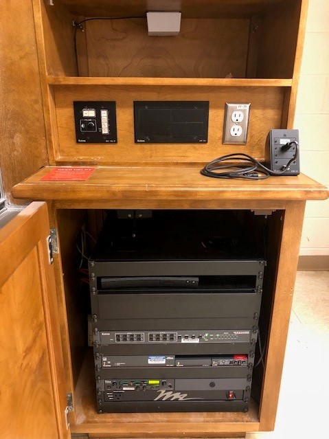 A view of the open cabinet with HDMI input, Wireless Input, Blu-Ray DVD, and push button controller