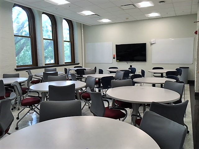 This is a view of the room with student desks, a LCD monitor, and white boards.