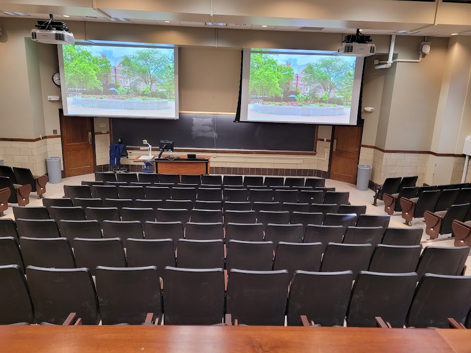 A view of the classroom with auditorium seating, chalkboard, and instructor table