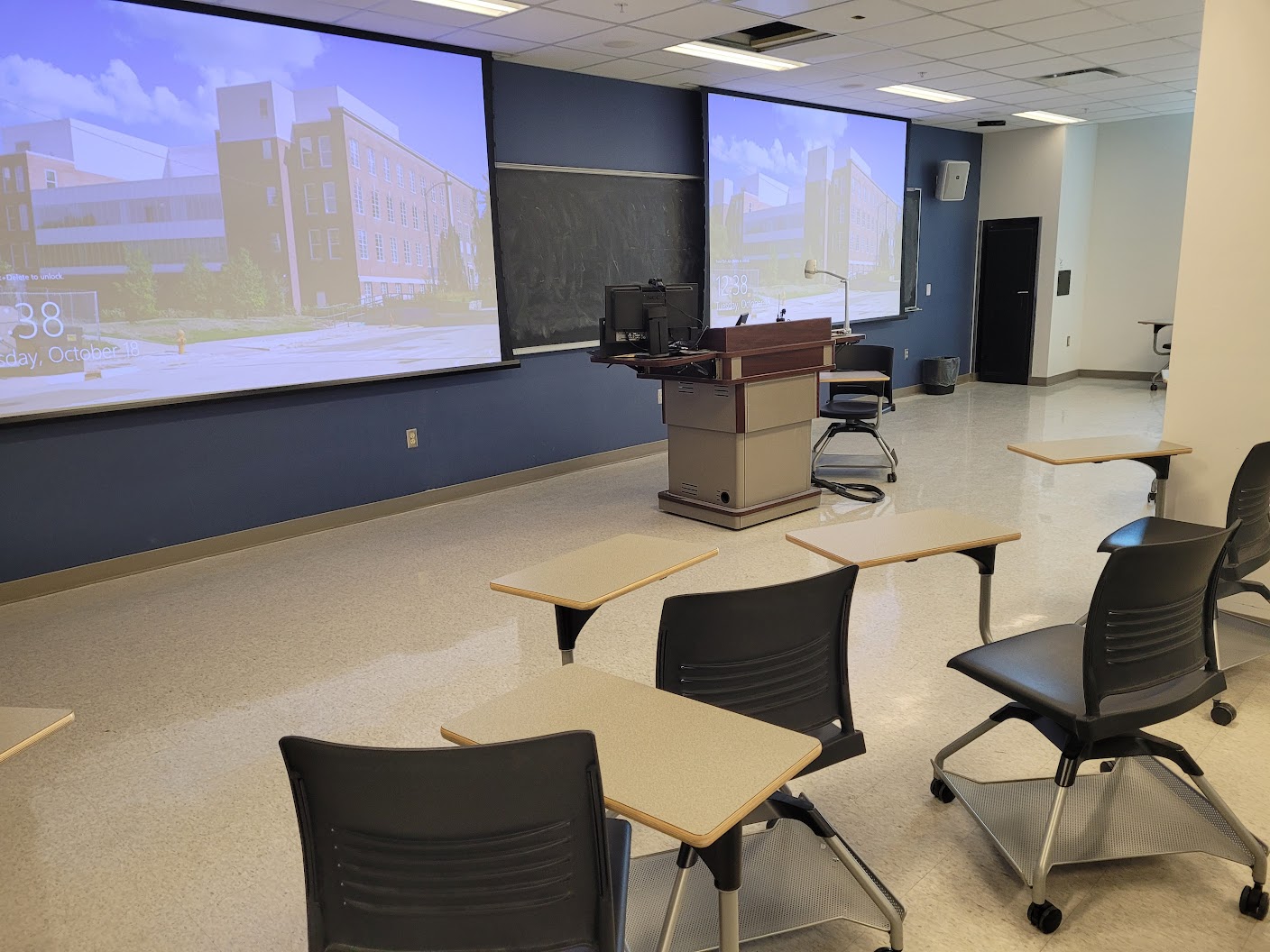 This is a view of the room, with a front lecture table and white boards.