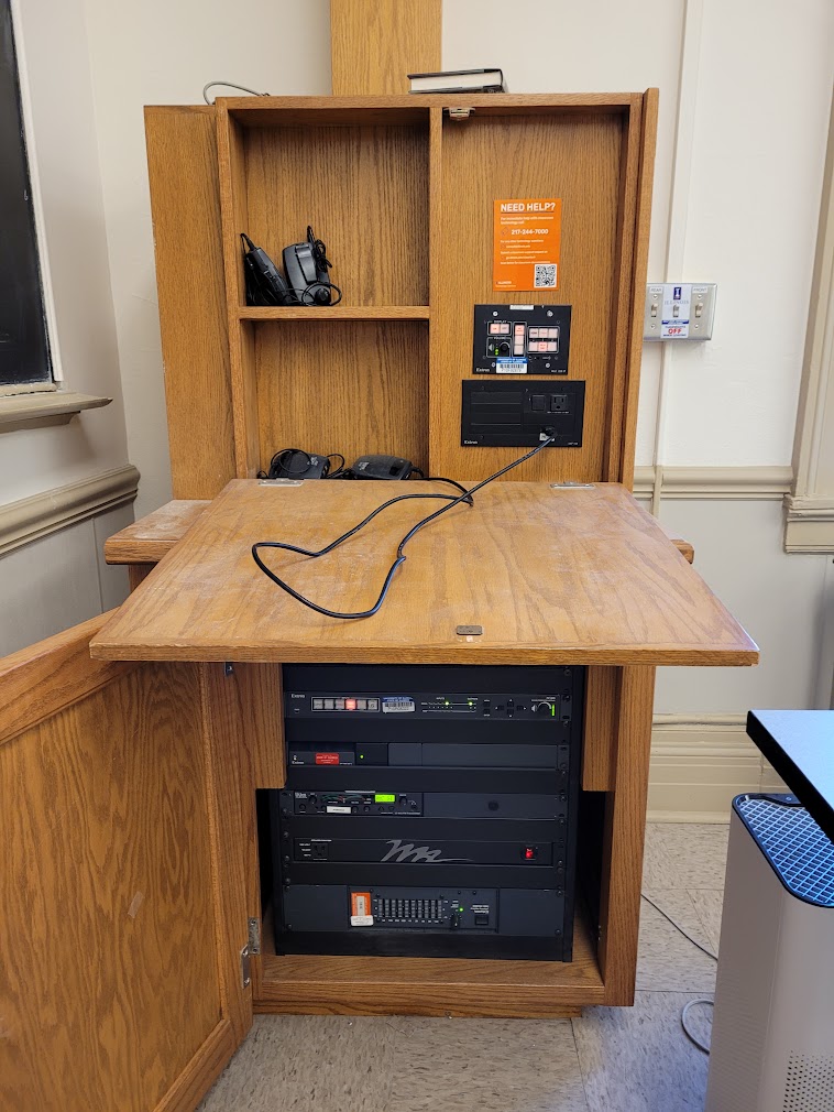 A view of the open cabinet with a push button controller and audio visual rack.