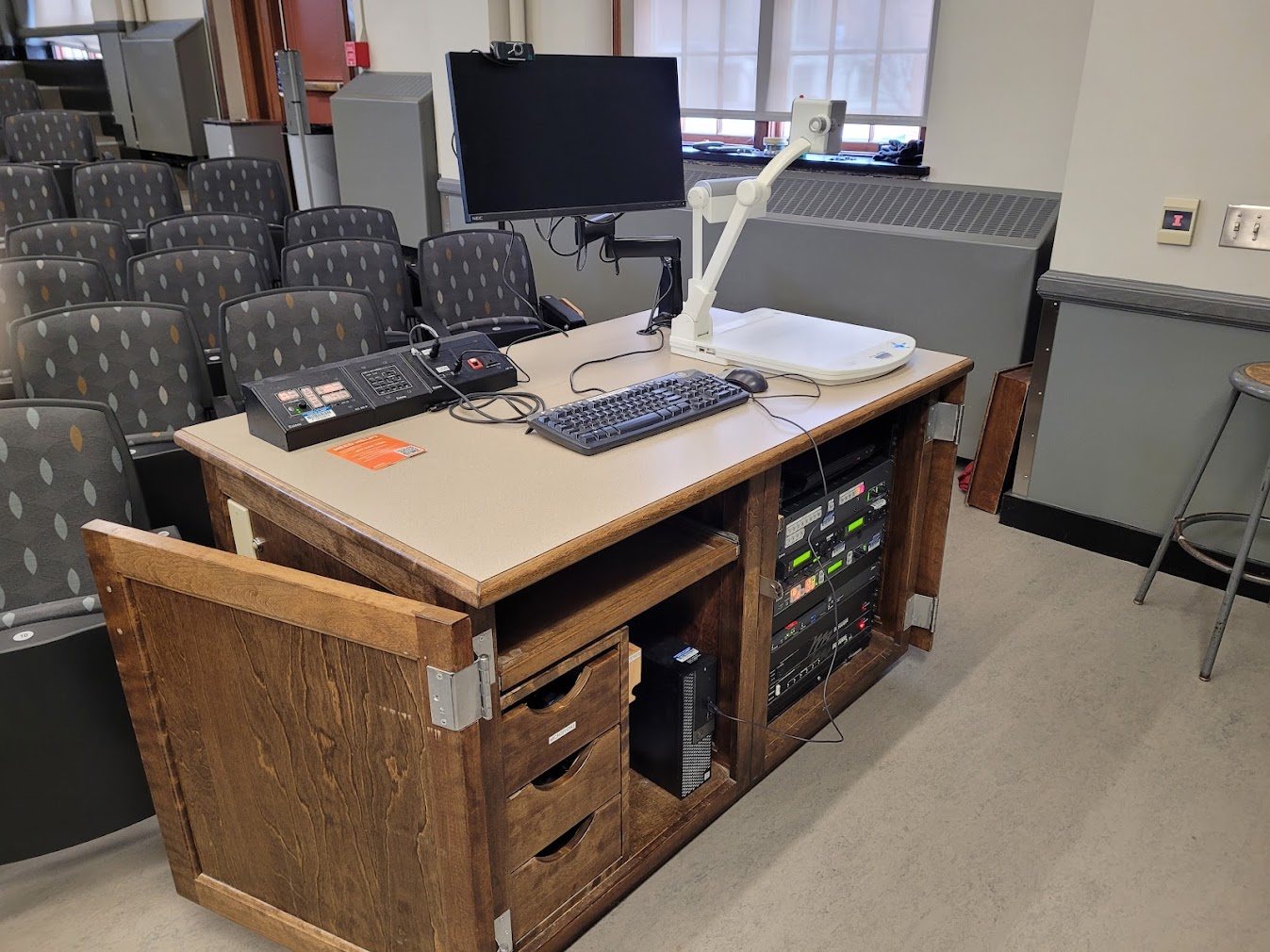 A view of the open cabinet with a computer monitor, HDMI input, a push button controller, document camera, and audio visual rack.95459