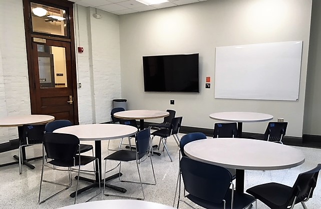 This is a view of the room with student desks, LCD monitor, and a white board.