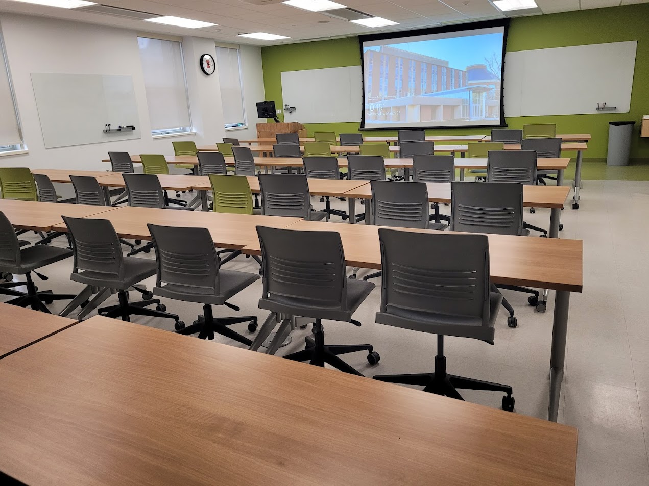 This is a view of the room, with student desks, a front lecture table, and a whiteboard.