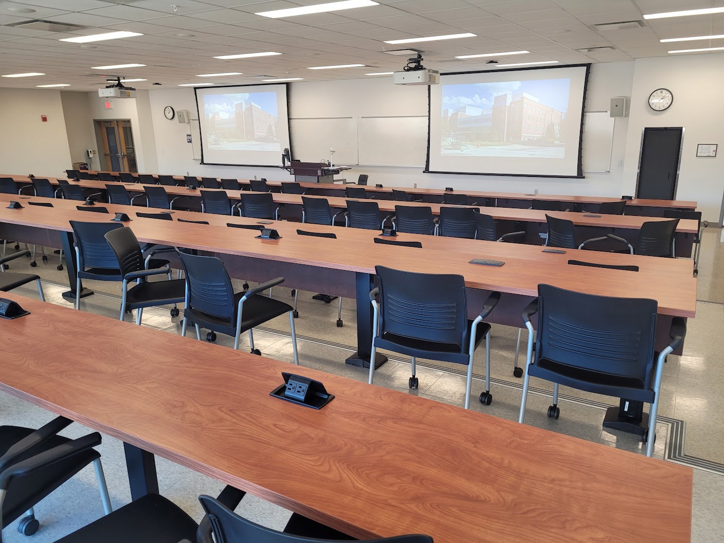 This is a view of the room, with a front lecture table and white boards.