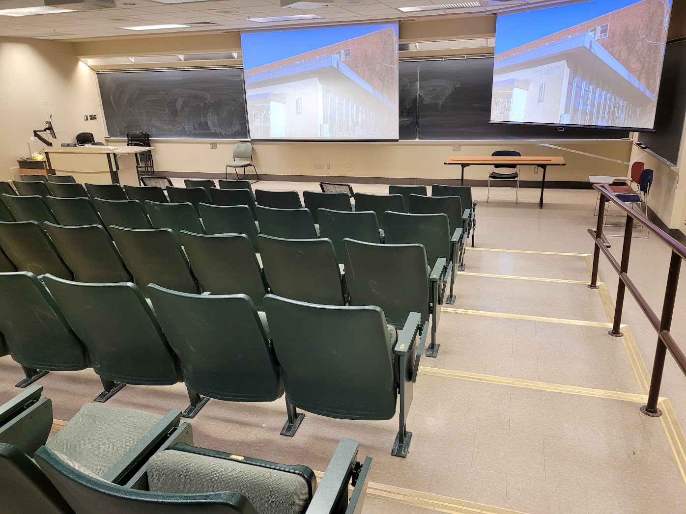 A view of the classroom with Theater Auditorium Seating, chalkboard, and instructor table in front.