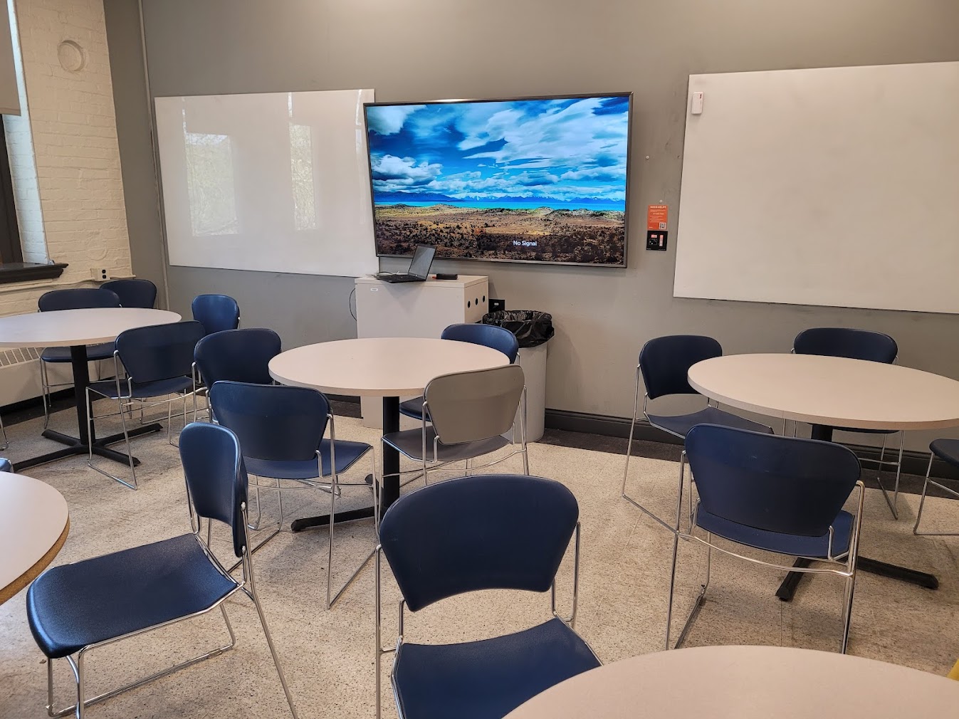This is a view of the room with student desks, LCD monitor, and white boards.