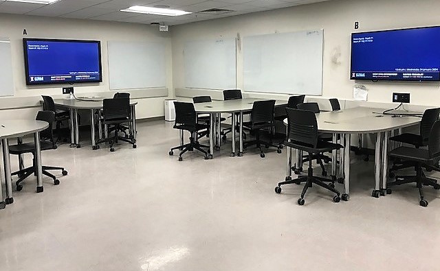 This is a view of the room with student desks grouped in pods with monitors and HDMI inputs.
