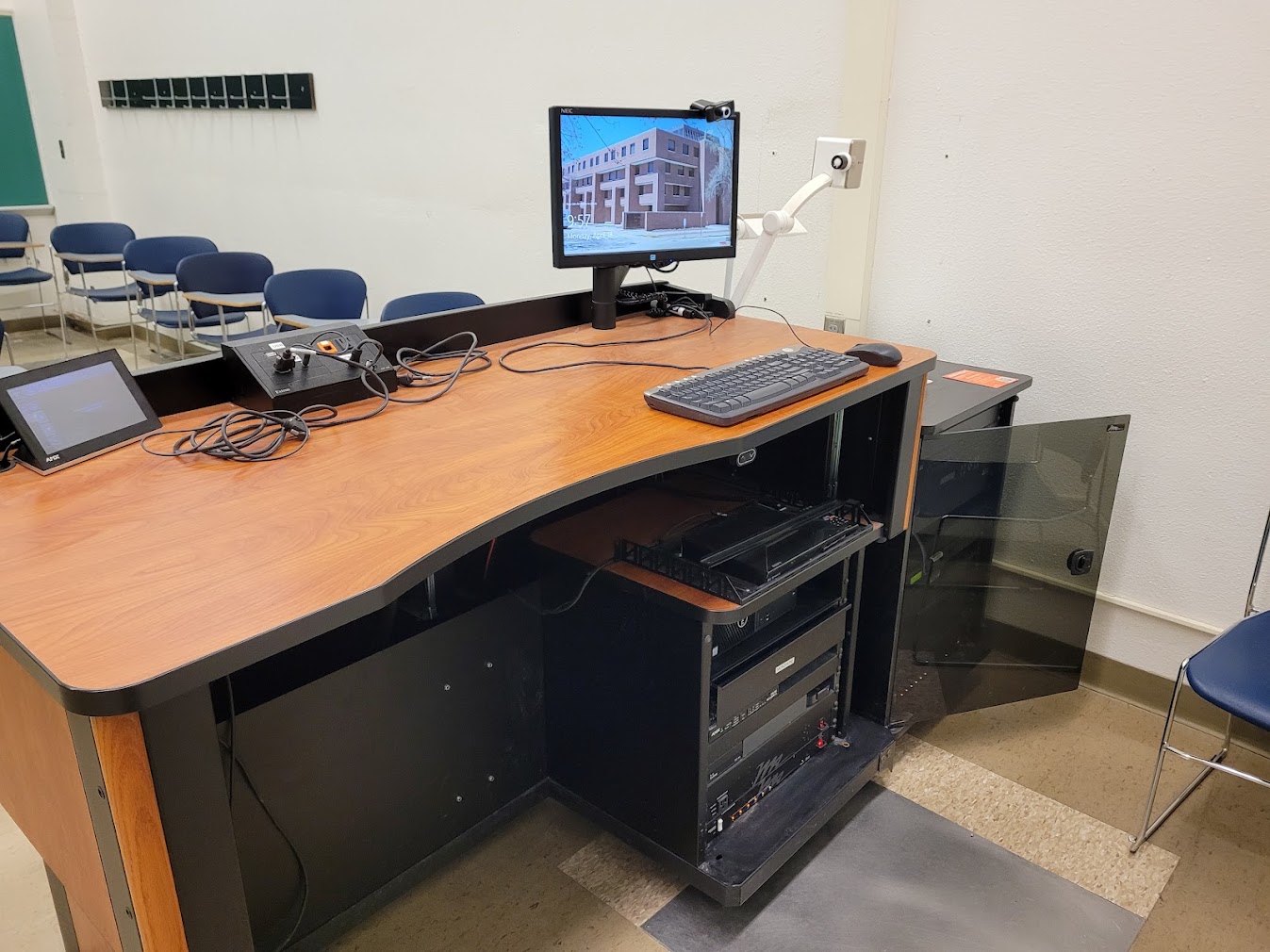 A view of the open cabinet with a computer monitor, VGA and HDMI inputs, touch panel controller, document camera, and audiovisual rack.