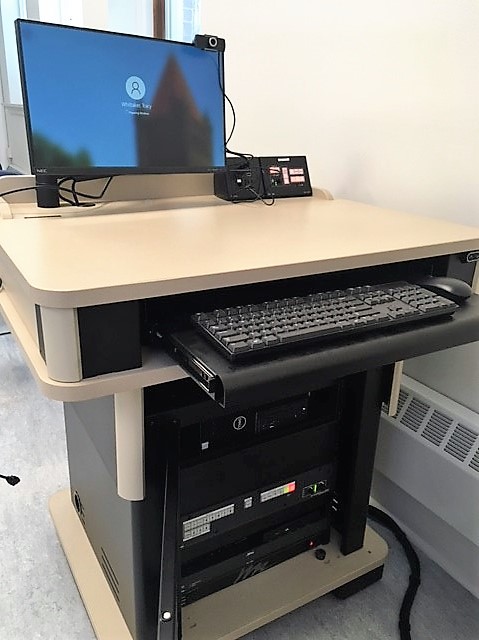 A view of the open cabinet with Computer, Monitor, Keyboard, HDMI input, a push button controller, and audio visual rack.