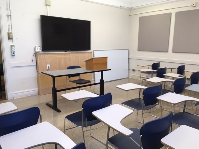 This is a view of the room, with student desks, a front lecture table, and a TV
