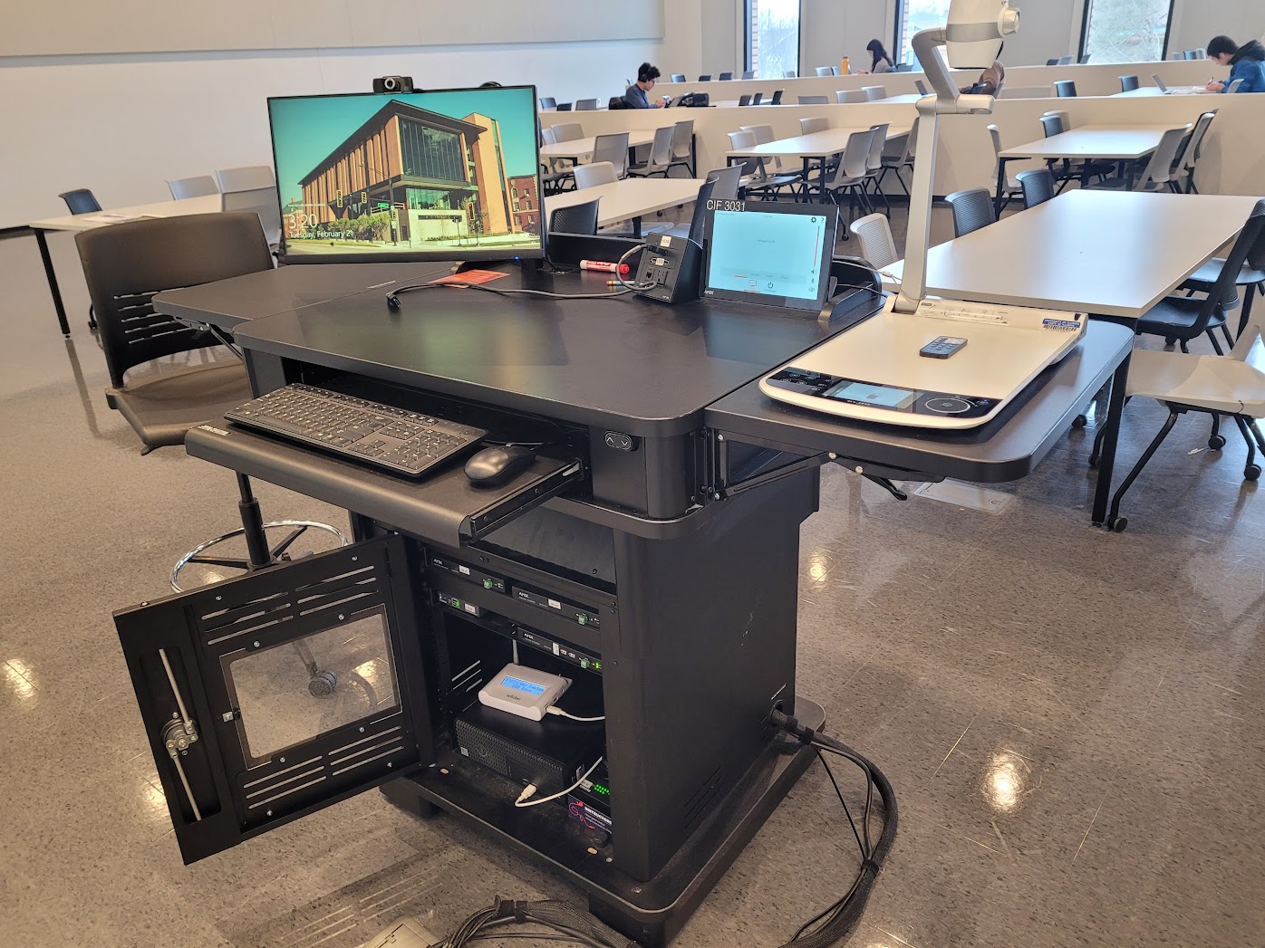 The instructor lectern with the control panel, microphones, and monitor on top and the PC, iClicker Base Station, and sound equipment inside.